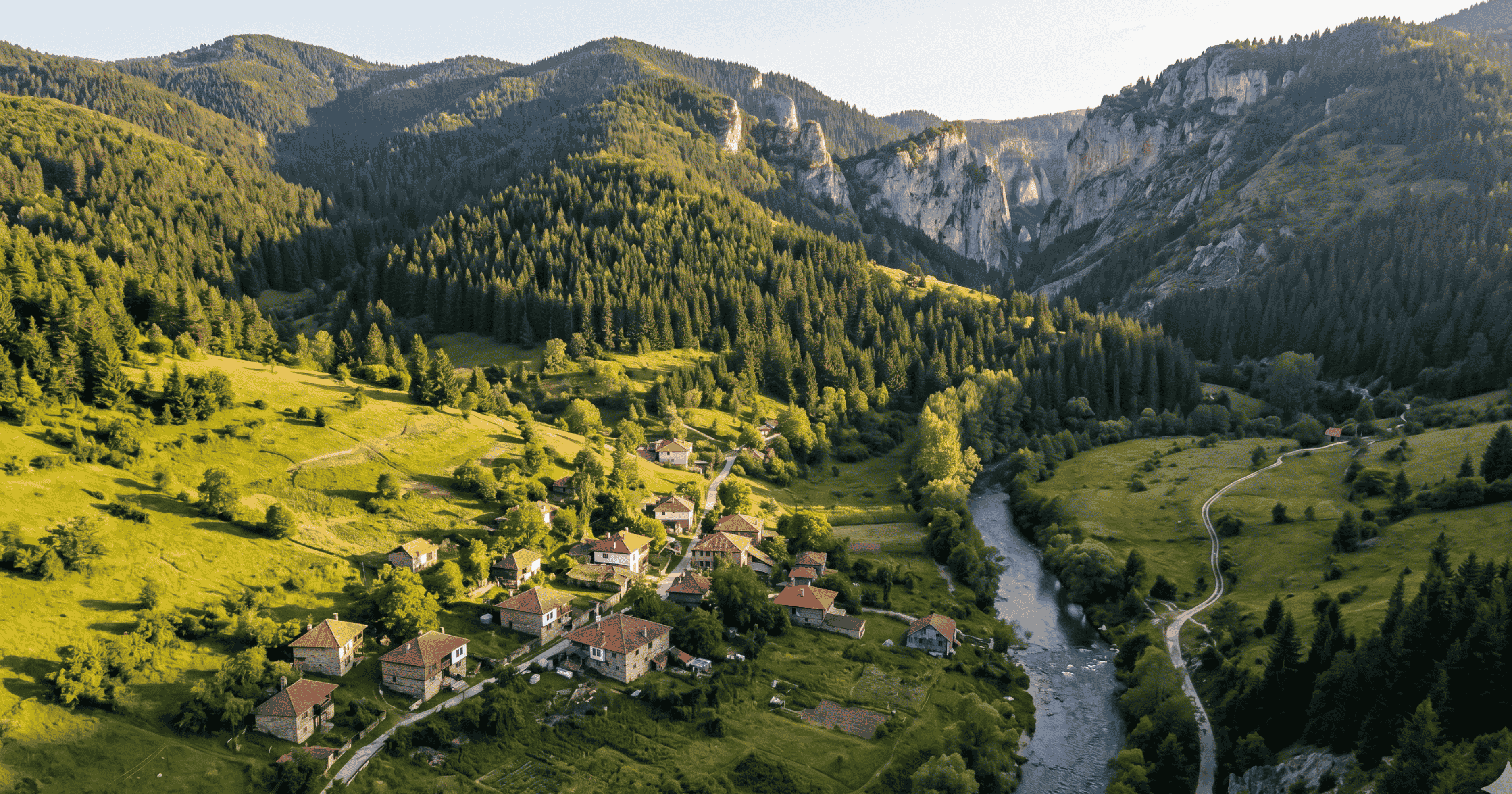 Panoramic view of the Rhodope Mountains in Bulgaria — pine forests and a valley with a small village in the distance